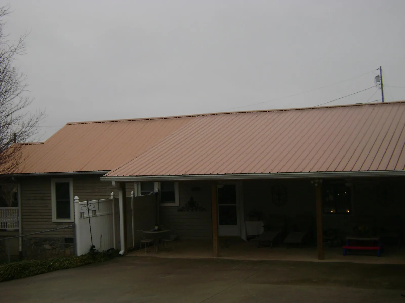 Copper toned metal roof over a wide covered patio in Dryden